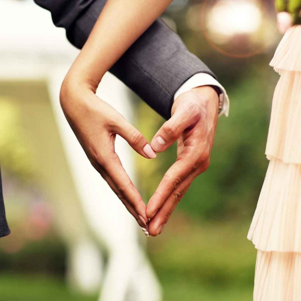 wedding couple forming heart with hands