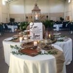 3 round draped tables clustered together and set up for a wedding reception