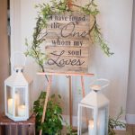 Wood crates and white lanterns with a pallet wood Bible verse "I have found the One whom my soul loves" wedding decor