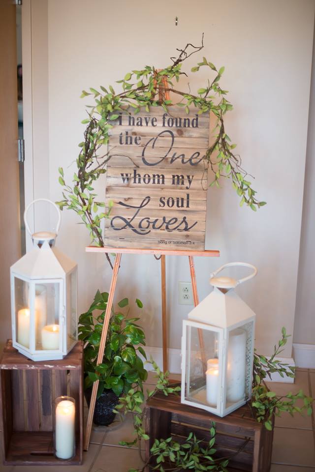 Wood crates and white lanterns with a pallet wood Bible verse "I have found the One whom my soul loves" wedding decor