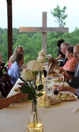 bottle lights in wine bottle with white roses at a wedding reception