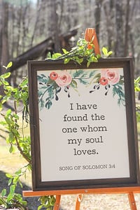 Floral Bible verse sign, "I have found the one whom my soul loves" on an easel for a wedding