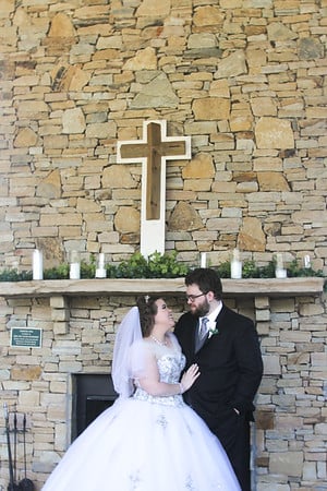 Wood cross on a rock fireplace at wedding 