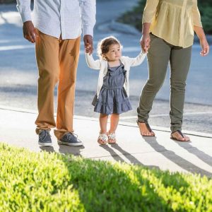 parents and child holding hands 